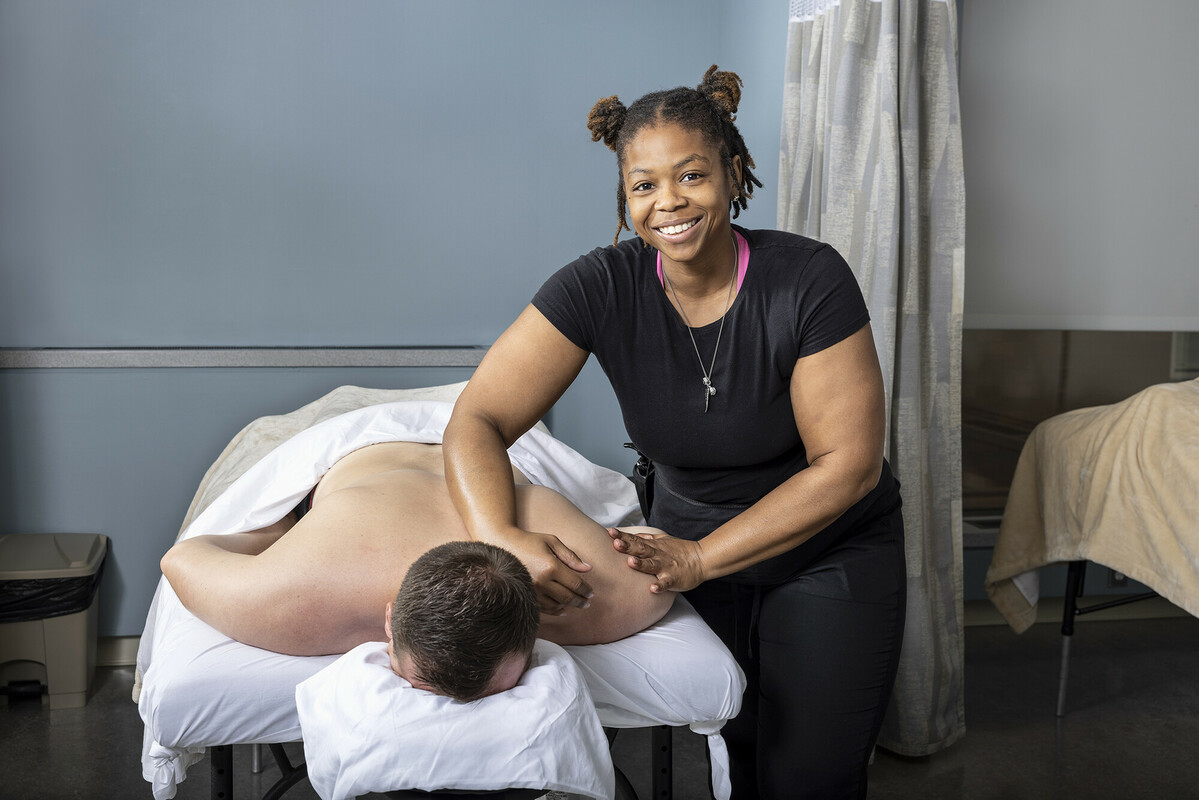Massage therapy student giving someone a massage on a massage therapy table