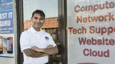 Person smiling outside computer store