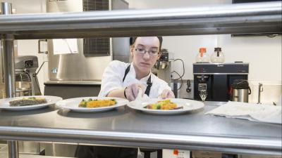 Culinary arts student setting plate