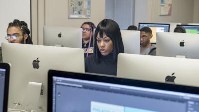 Students work at computers in computer classroom.