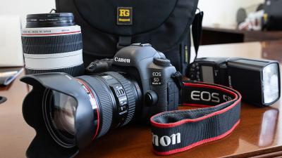 Image of camera, lens, flash and camera bag on a table.