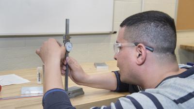 Engineering student works with a measuring tool.