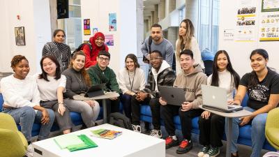 A large diverse group of students smile for the camera.