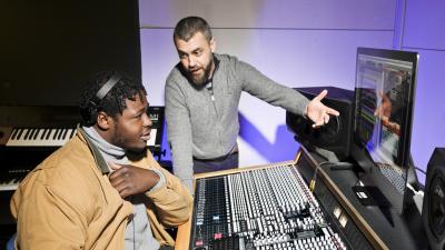 An instructor explains a soundboard to a student.