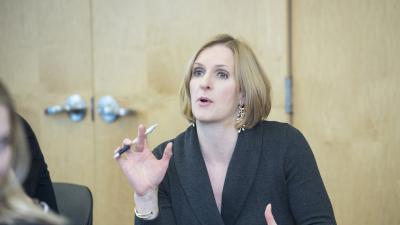 Business woman with pen in her hand speaks.