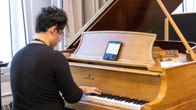 Student Plays and baby grand piano.