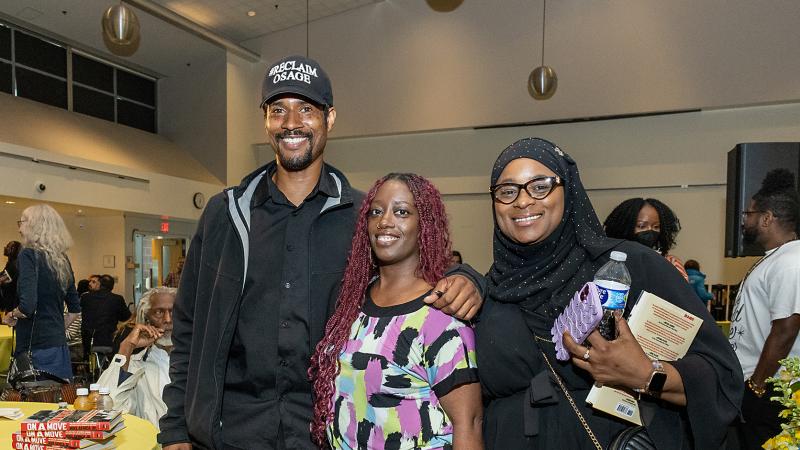 Mike Africa Jr. posing with event attendees after signing their books