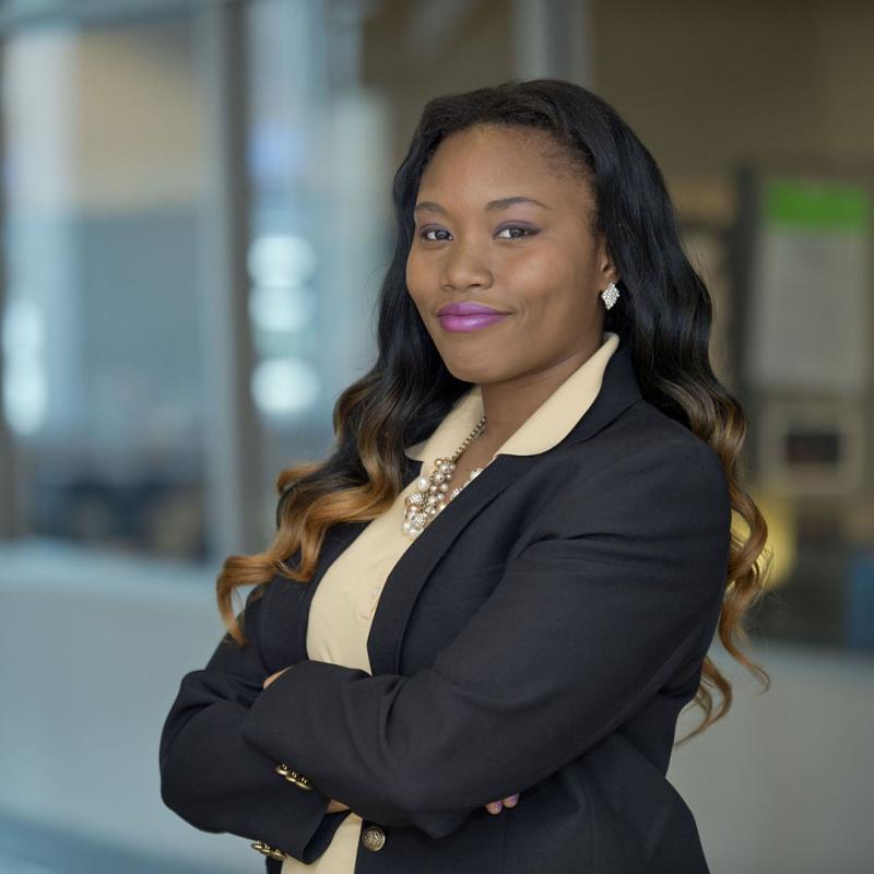 Confident business woman with arms crossed poses for the camera.