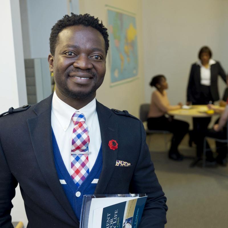 Gentleman in business attire holding text books.