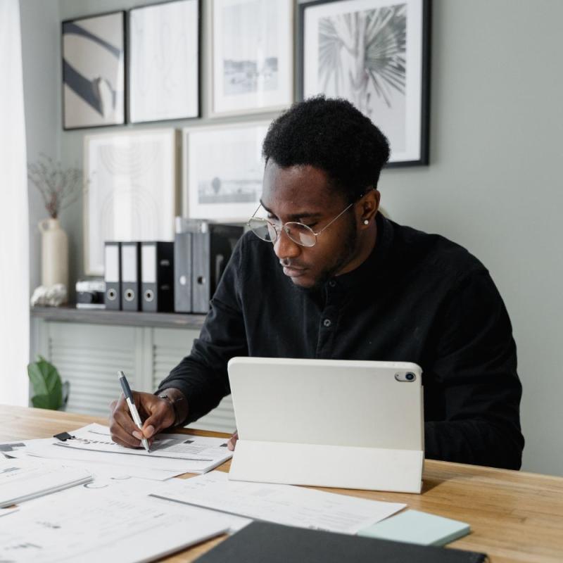 An accountant works on financial records in his sunny, modern office