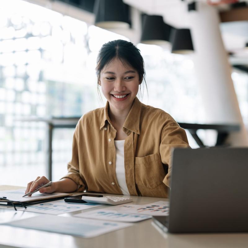 An accountant reviews financial records on a laptop