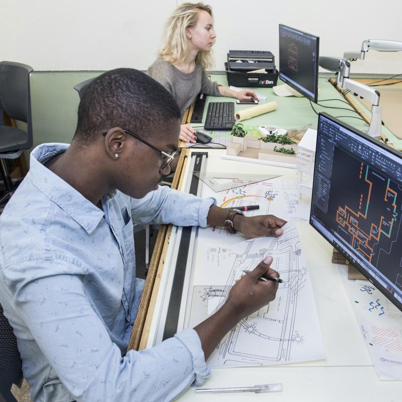 Students work on construction projects at computers.