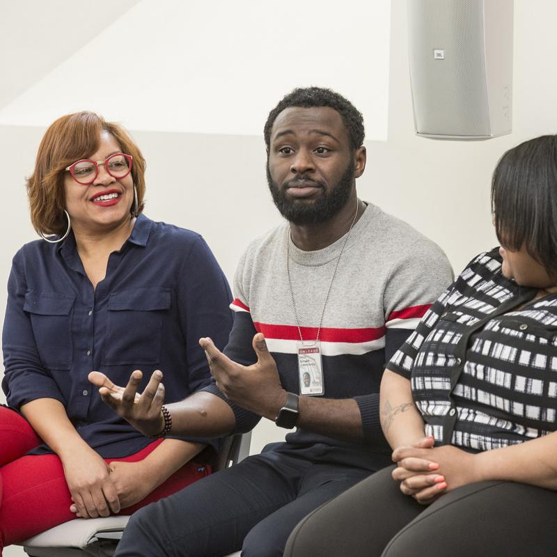 Man speaks to a group seated in a circle.