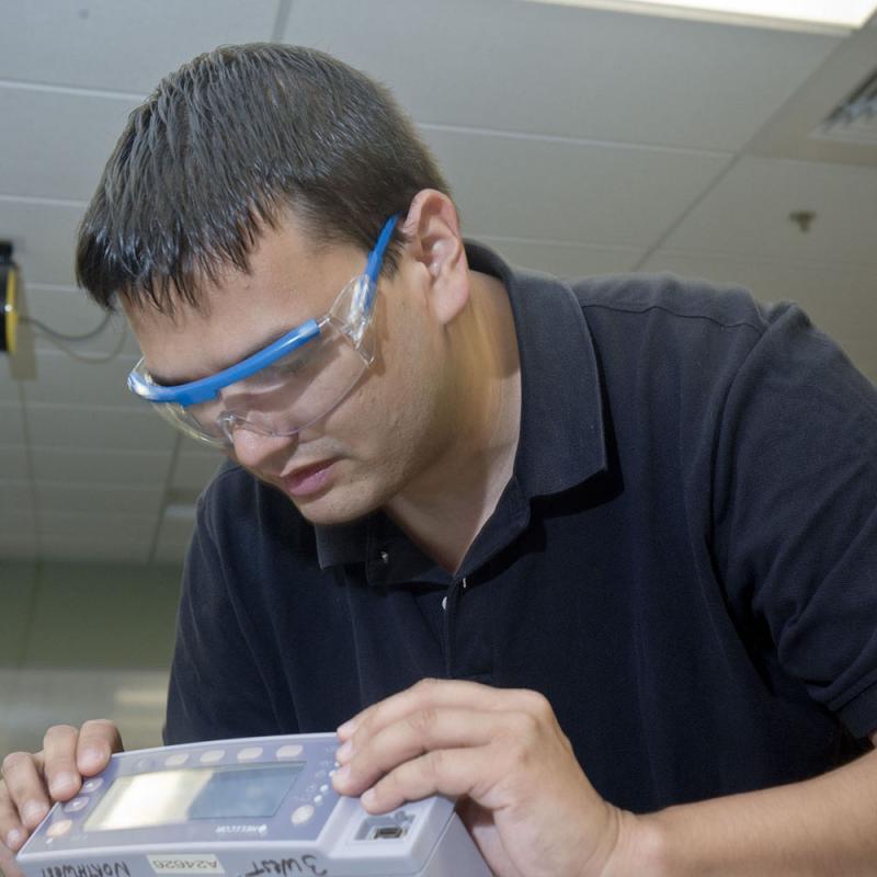 A student works on medical equipment in the classroom
