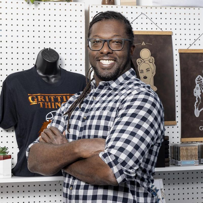 Business owner poses in front of his merchandise