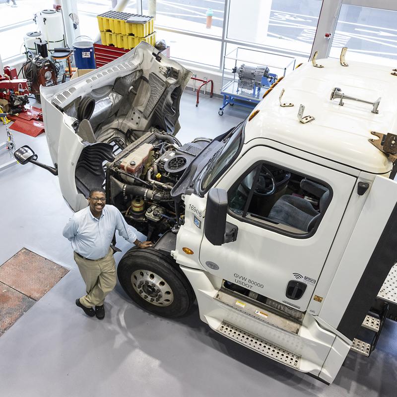 View from above of instructor standing next to a large truck cab.