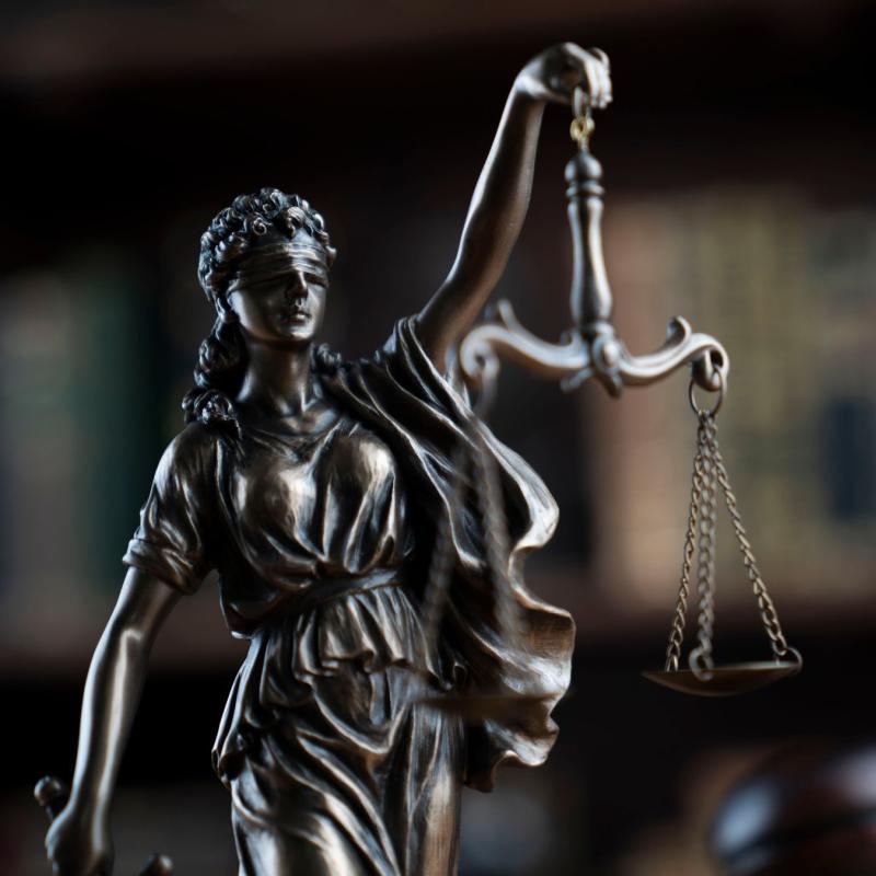 Closeup of the blind statue of Justice holding a scale.