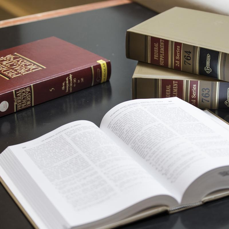 Law book open on table with other books in background.