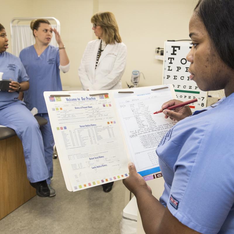 Woman holds medical chart.