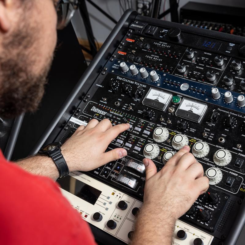 Closeup of hands working with sound equipment.