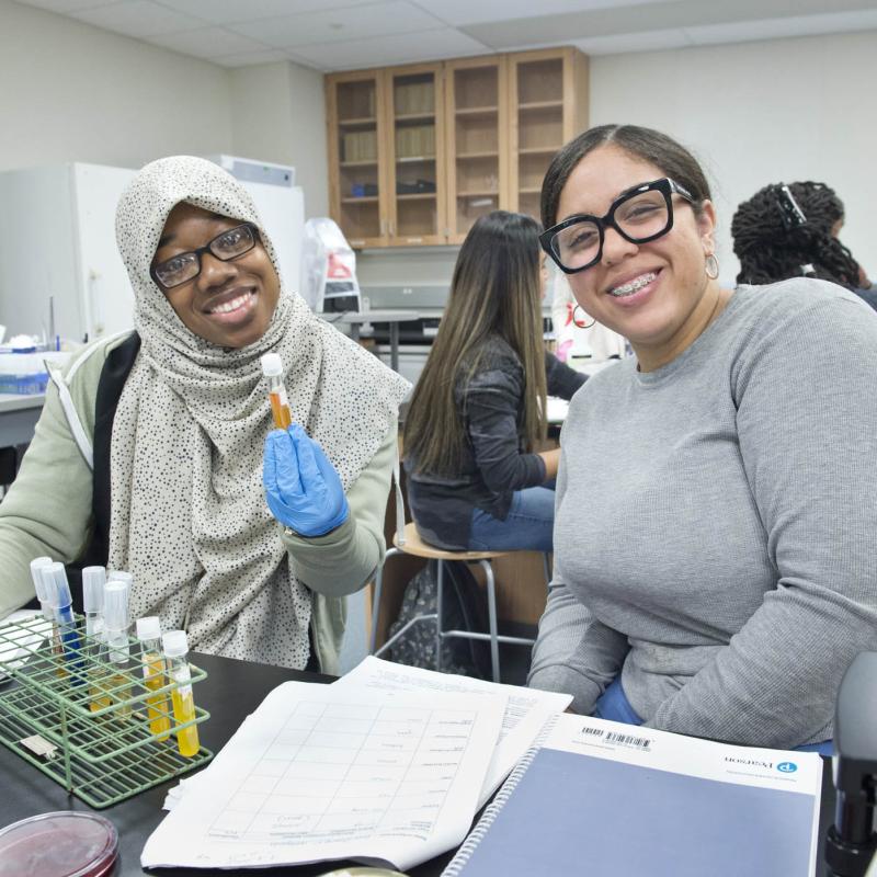 a student and teacher smile in biology class