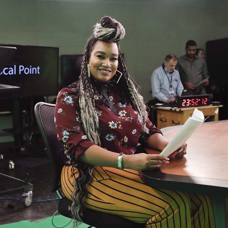 A student producer reviews script notes in the College's multimedia studio