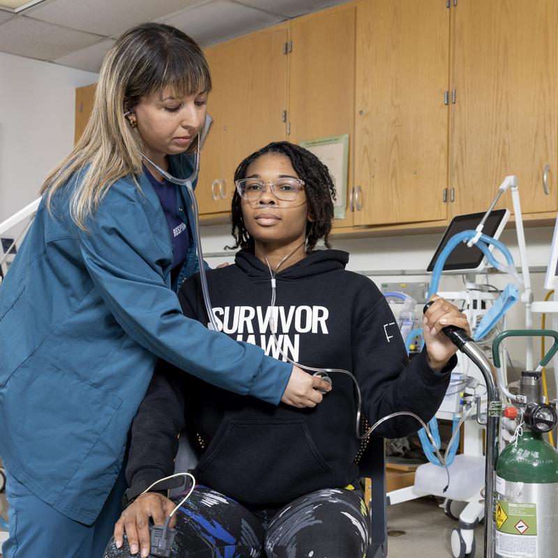 Therapist works with patient checking her breathing.