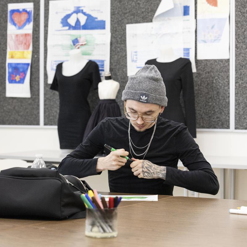 Student works on a design in the classroom.