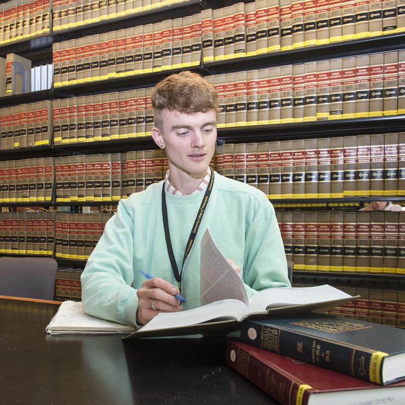 Student in law library reading books.