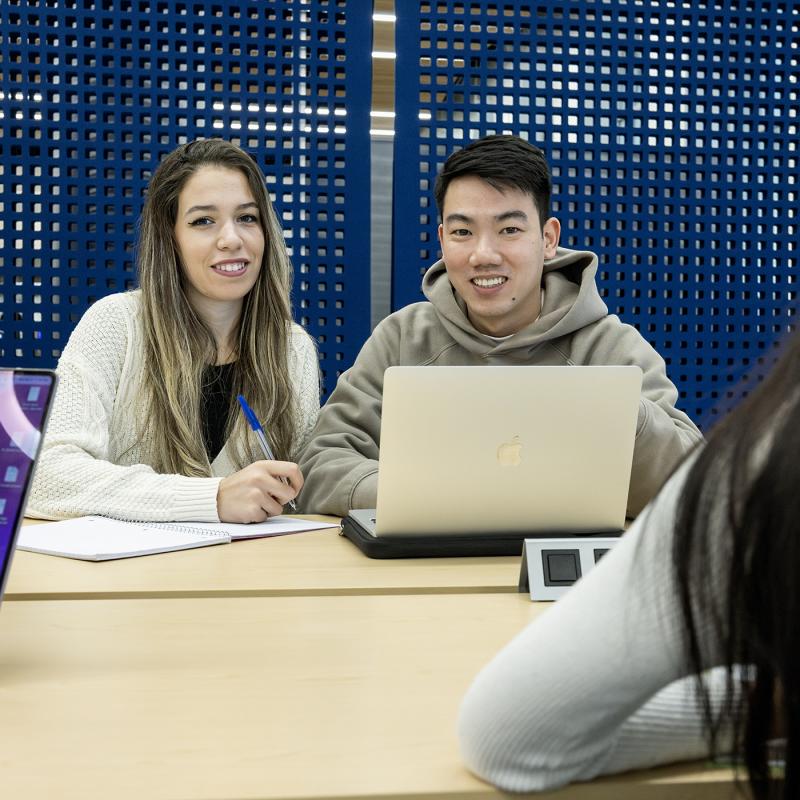 Students in the library with a laptop