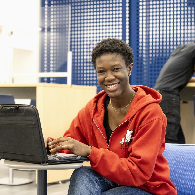 High school student working on a laptop in the library