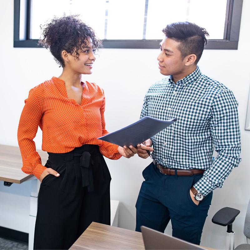 Two people chatting with a folder