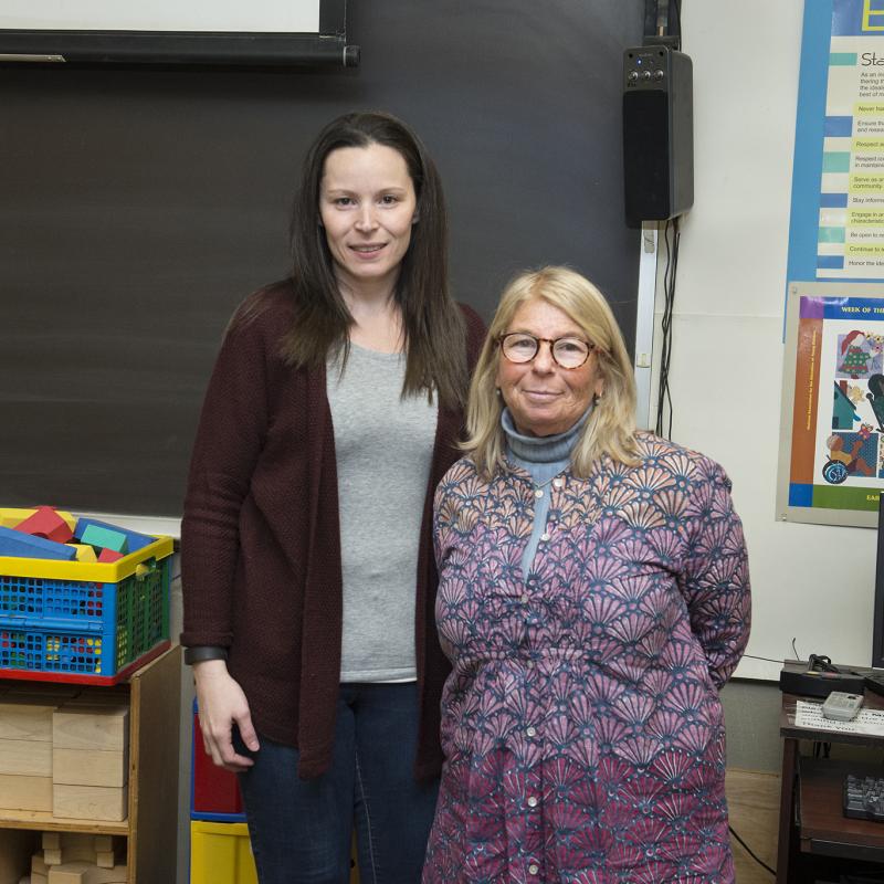 Two people smiling in a classroom