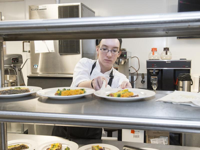 Culinary arts student setting plate