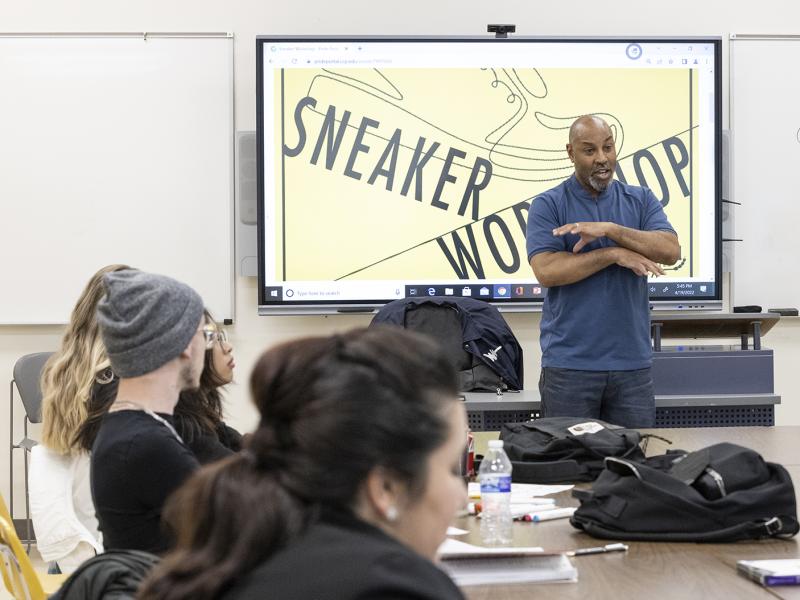 A teacher giving a lesson to a classroom with students.