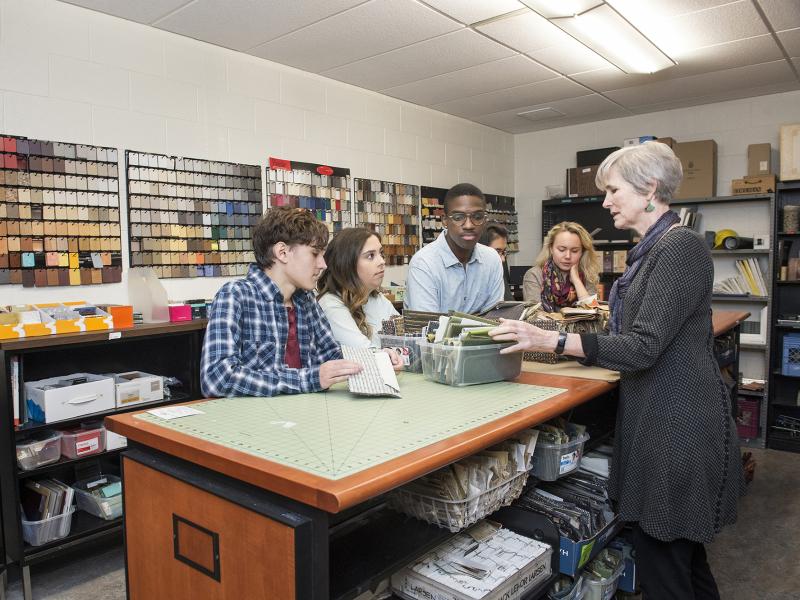 Instructor shows students swatch samples.