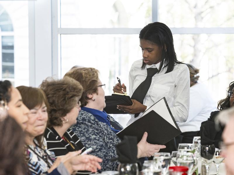 A waiter takes an order from a customer