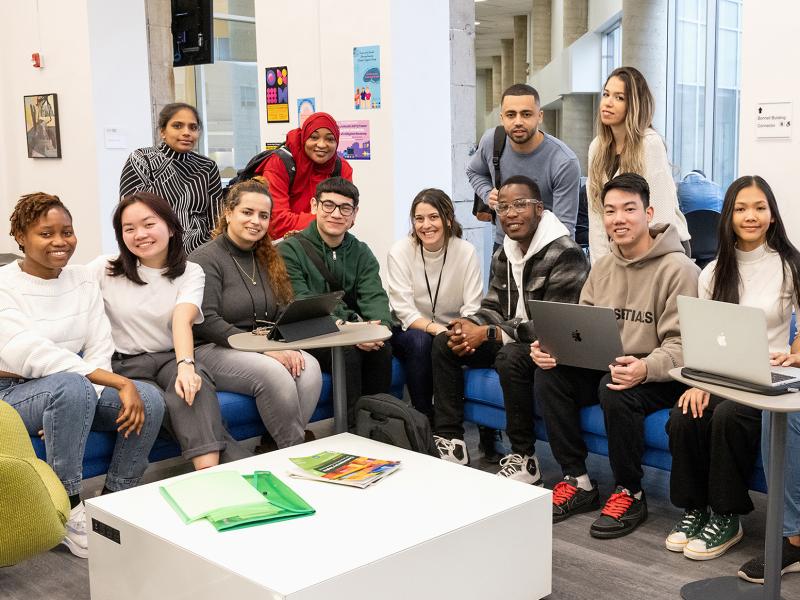 A large diverse group of students smile for the camera.
