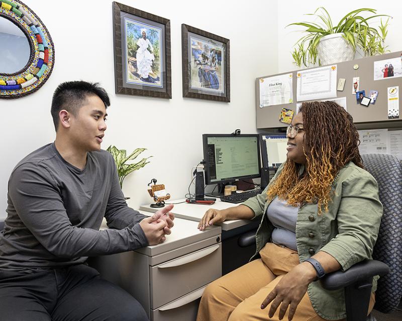 A student speaks to a counselor in her office at the College