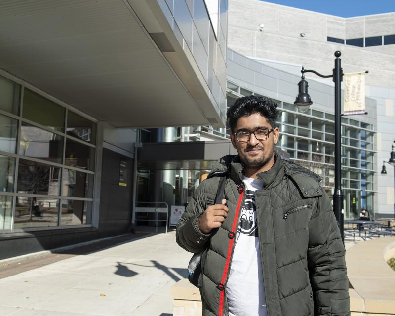 Student standing outside of the Bonnell Building smiling