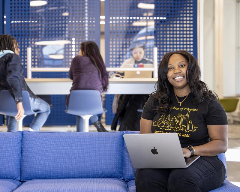 Student sitting in the library working on a laptop