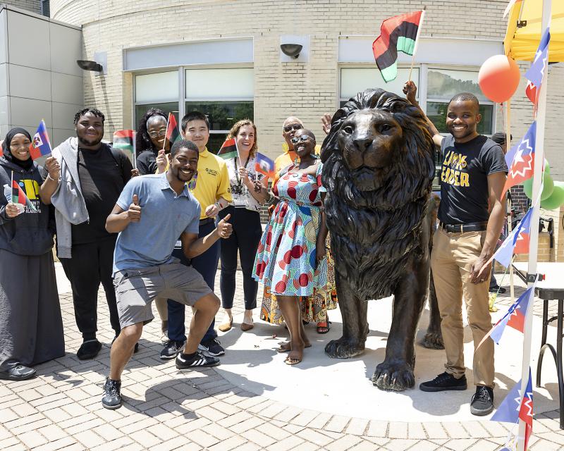 Students surrounding lion statue on Juneteenth 