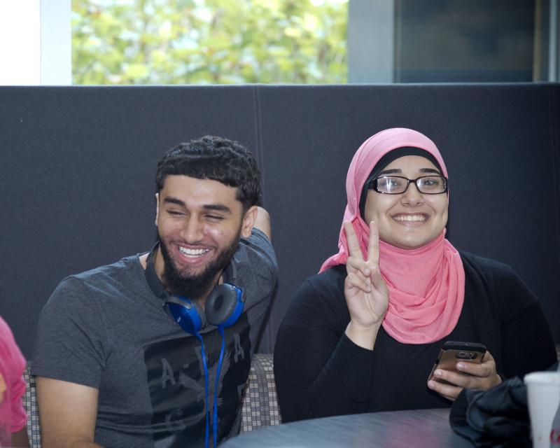 Students smiling at the camera, one student making a peace sign