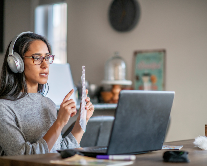 Woman with headphones on in an online meeting.   