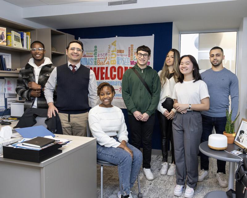 A large and diverse group of students smile for the camera