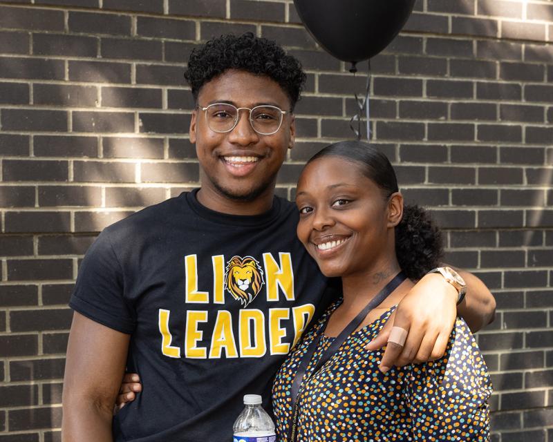 A student leader and a teacher smile and pose for the camera.