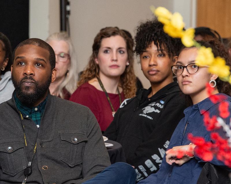 Teachers sit in and look up during a presentation.