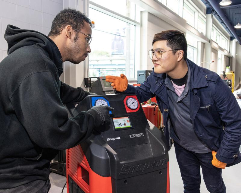 two students at a snap on tools machine