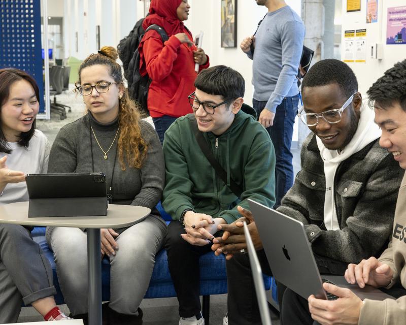 Students sitting together in the Library Learning Commons working on laptops